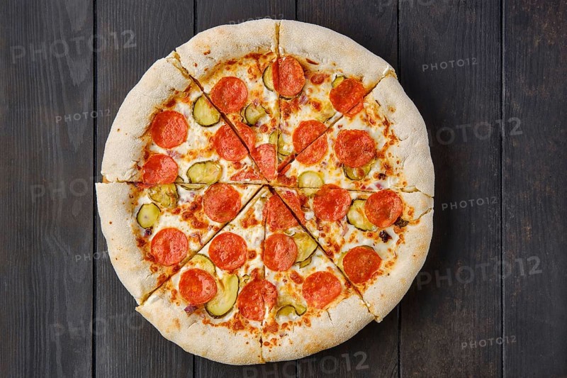 Top view of pizza pepperoni with cheese crust on dark wooden table
