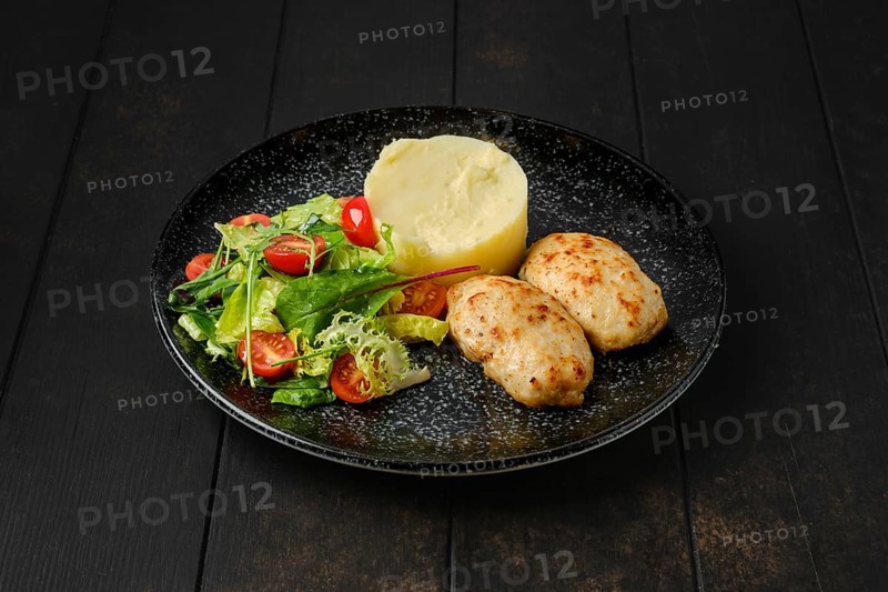 Meat cutlet with mashed potato and fresh vegetables on a plate