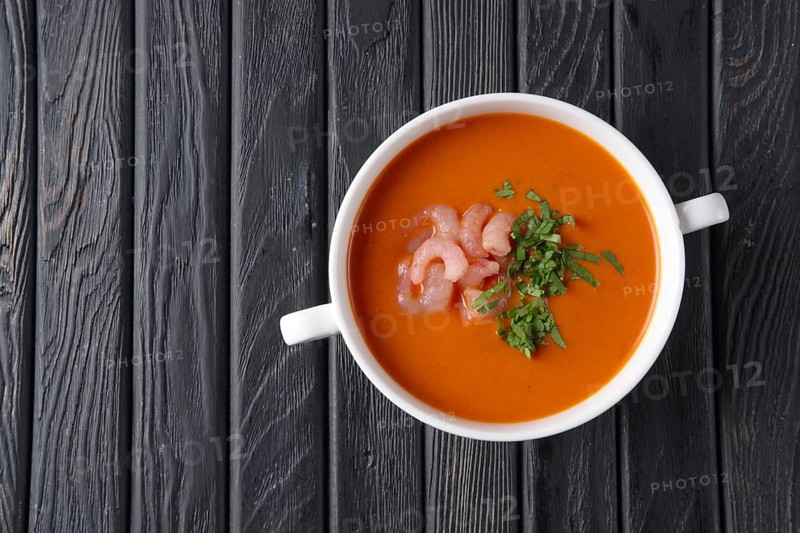 Top view of rustic tomato soup with shrimps