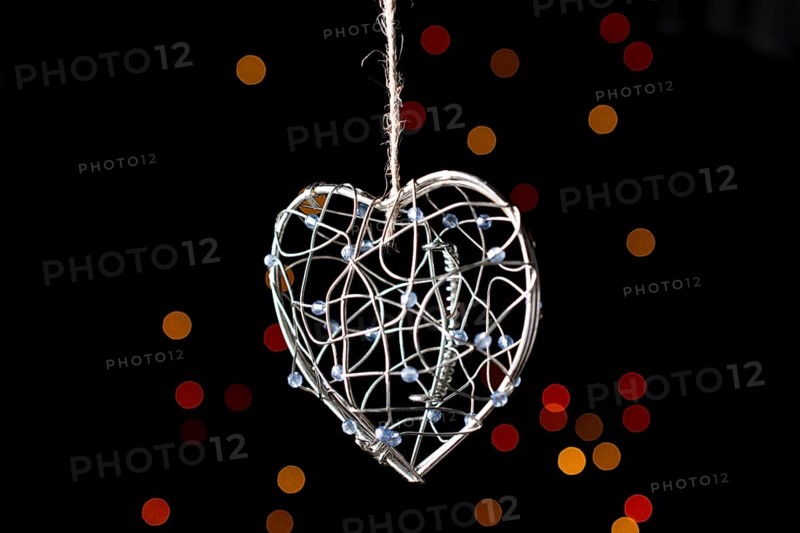 Heart shaped metal cage on a bokeh light background