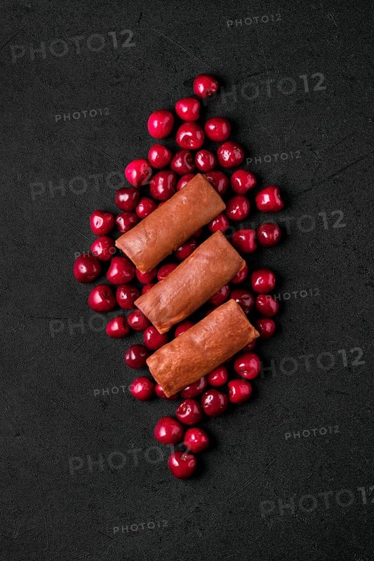 Overhead composition with thin chocolate pancakes stuffed with curd