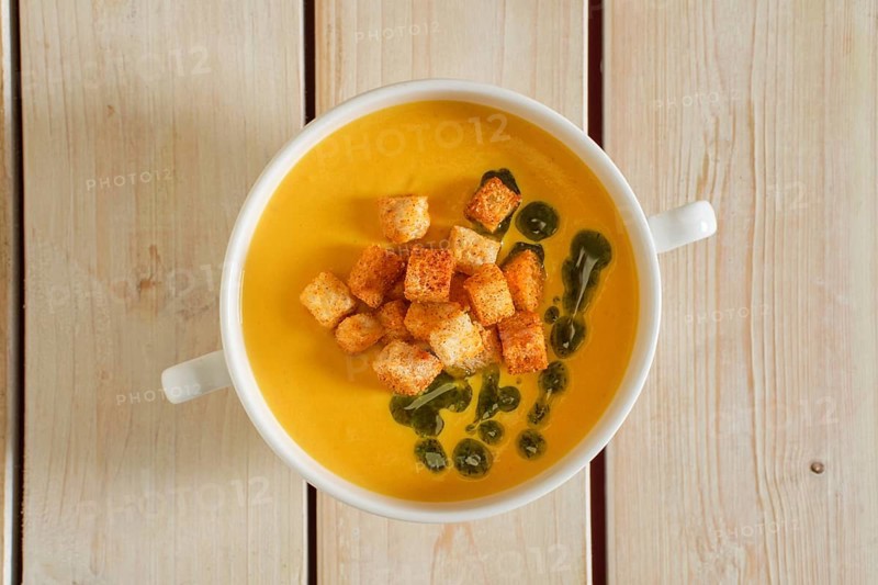 Top view of mashed peas soup with curry and crouton