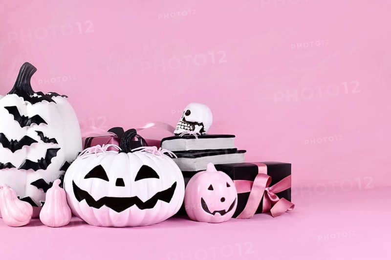 Pink Halloween decor with pink and black and white pumpkins and copy space