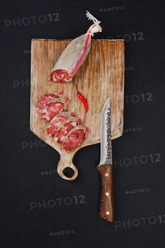 Top view of sliced dry beef sausage on cutting board