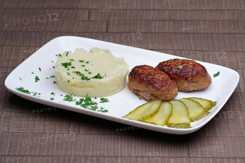 Cutlet with mashed potato and pickled cucumber