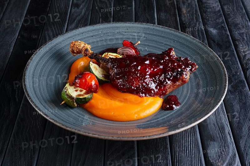 Fried duck thigh with carrot puree and zuccini