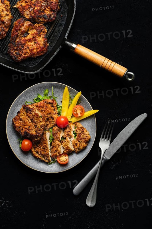 Pork chop fillet baked in oven with seasoning and herbs