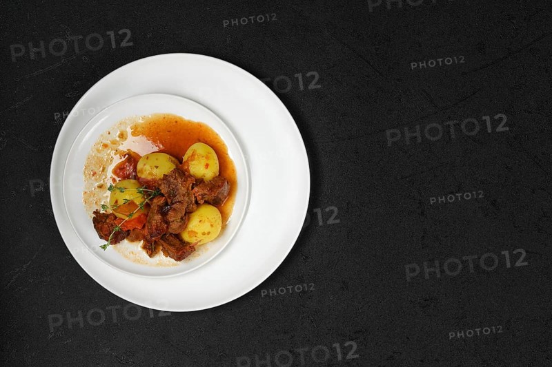 Overhead view of lamb stew with potato on a plate
