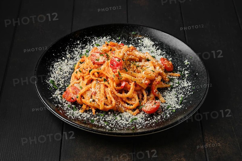 Spaghetti with tomato cherry and grated parmesan on a plate