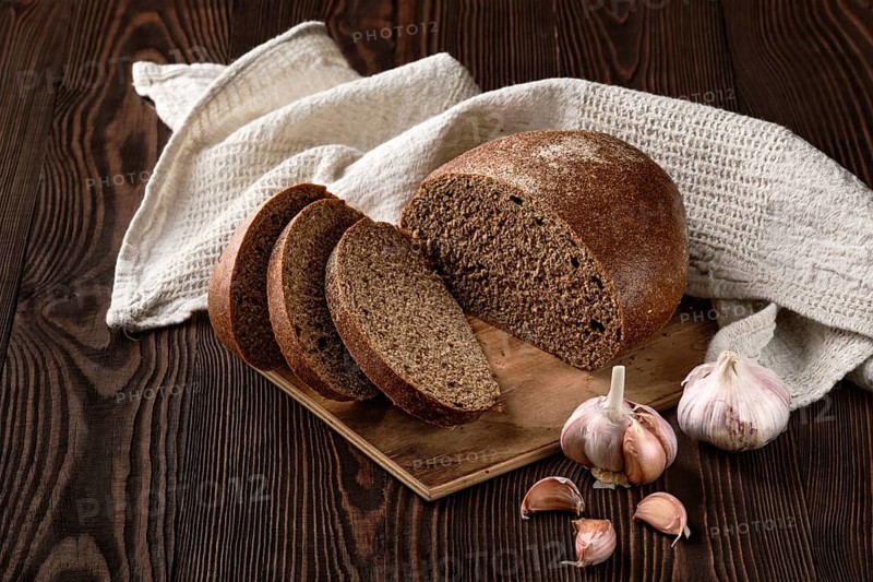 Brown garlic bread on cutting board on the table