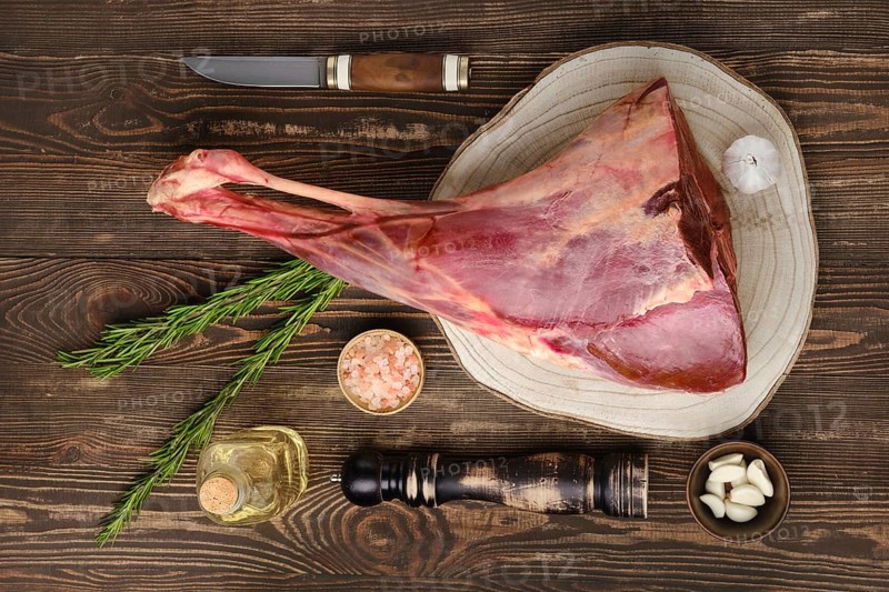 Raw fresh young beef leg on wooden background