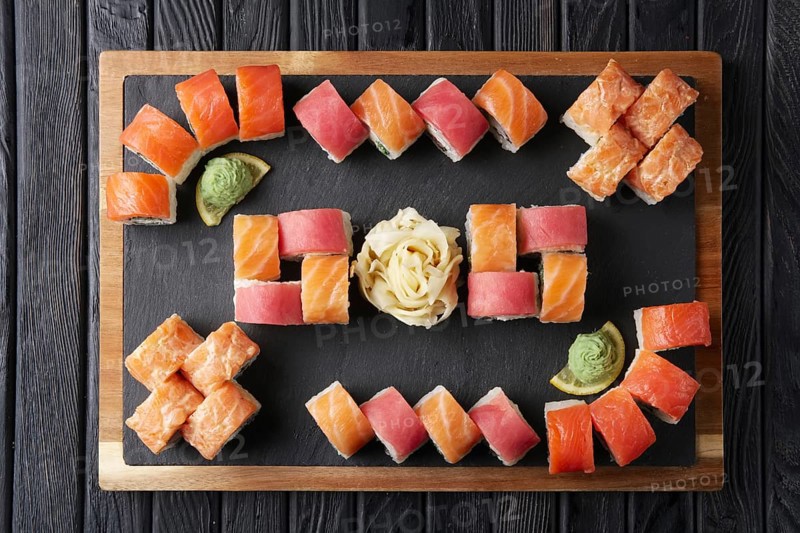 Big set of rolls served on stone plate. Layout for menu