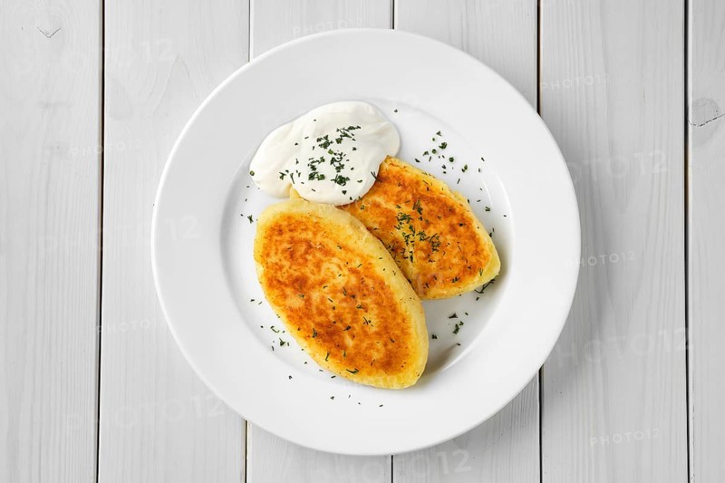 Top view of traditional belarussian potato cakes with sour cream