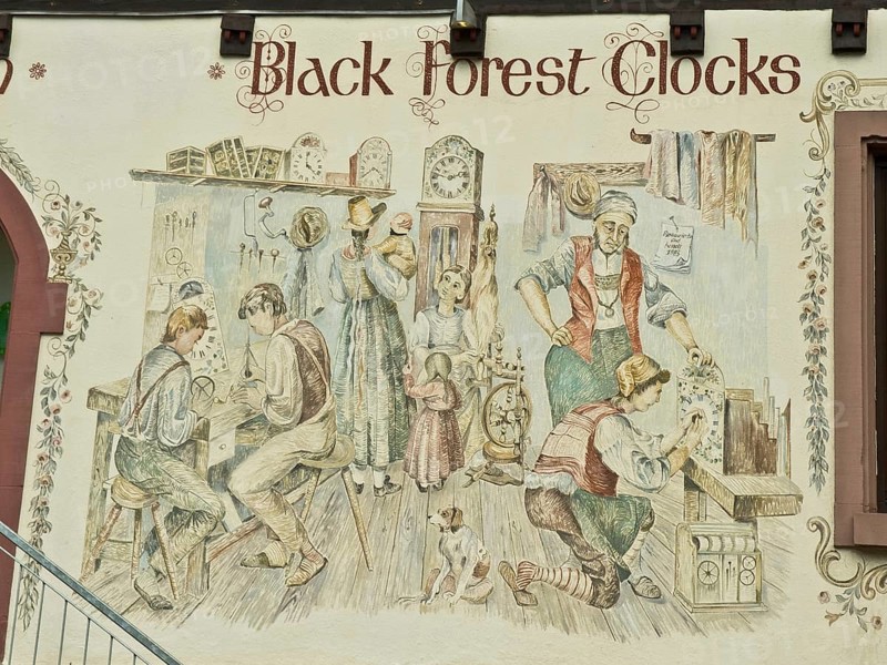 Clockmaker depicted in a facade painting of a Black Forest clock shop in Triberg
