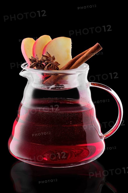 Jug with apple and cranberry tea isolated on black background