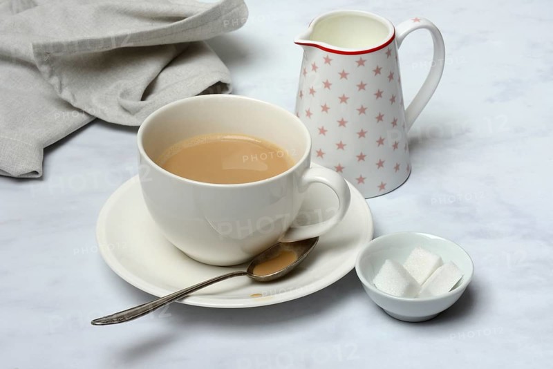 Cup of coffee and pot of milk