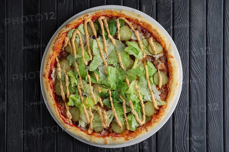 Top view of pizza wth pickled cucumber and salad