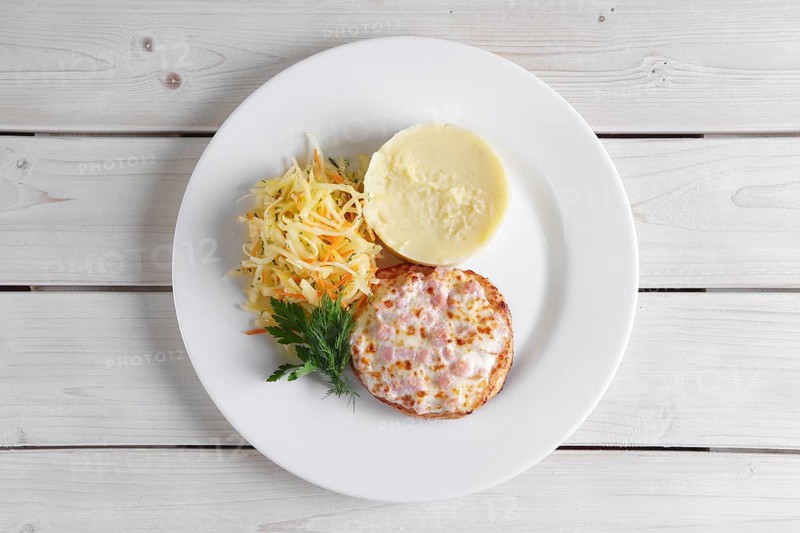 Fish cutlet with ham and melted cheese topping served with pickled cabbage and mashed potato