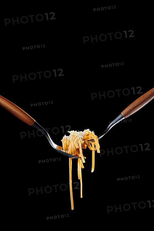 Cooked bigoli pasta twisted on fork with olive oil and parmesan