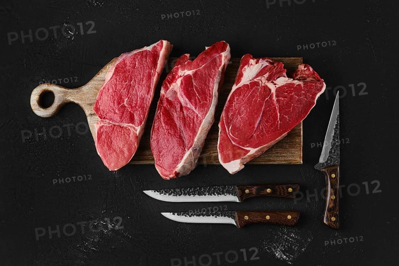 Prime black angus beef steaks on wooden board: top sirloin