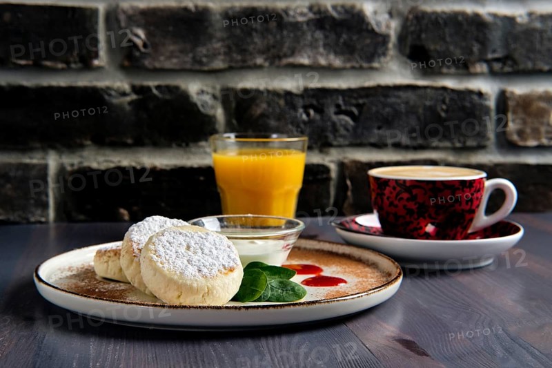 Traditional breakfast with cottage cheese pancake with sour cream