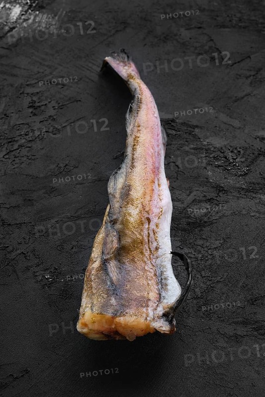 Frozen raw pollock carcass on wooden background