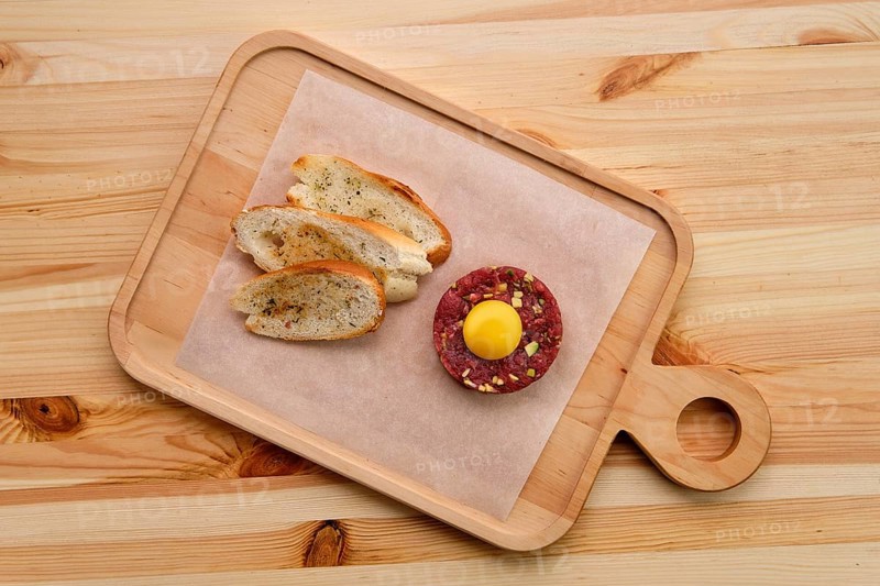 Classic steak tartare with egg and garlic bread