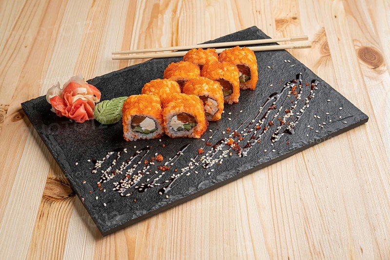 Set of rolls with wasabi and pickled ginger on stone serving board