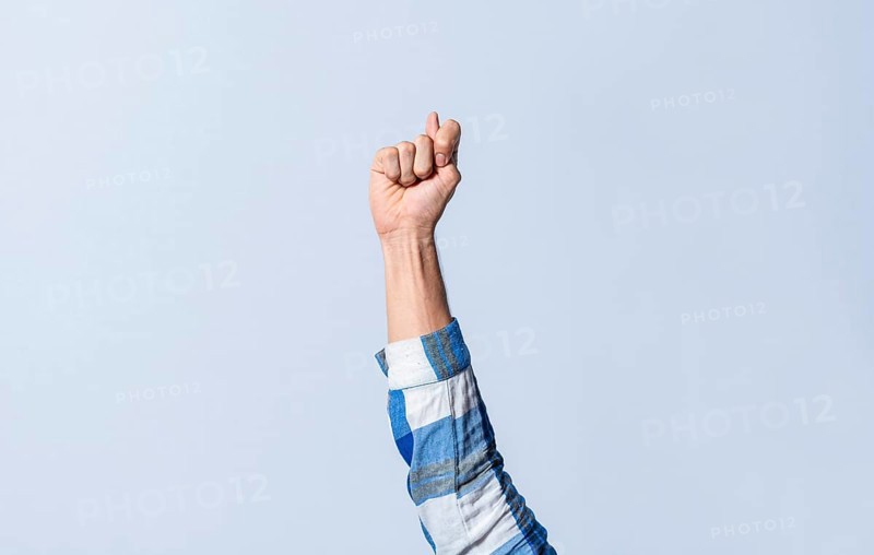 Hand gesturing the letter T in sign language on an isolated background. Man's hand gesturing the letter T of the alphabet isolated. Letter T of the alphabet in sign language