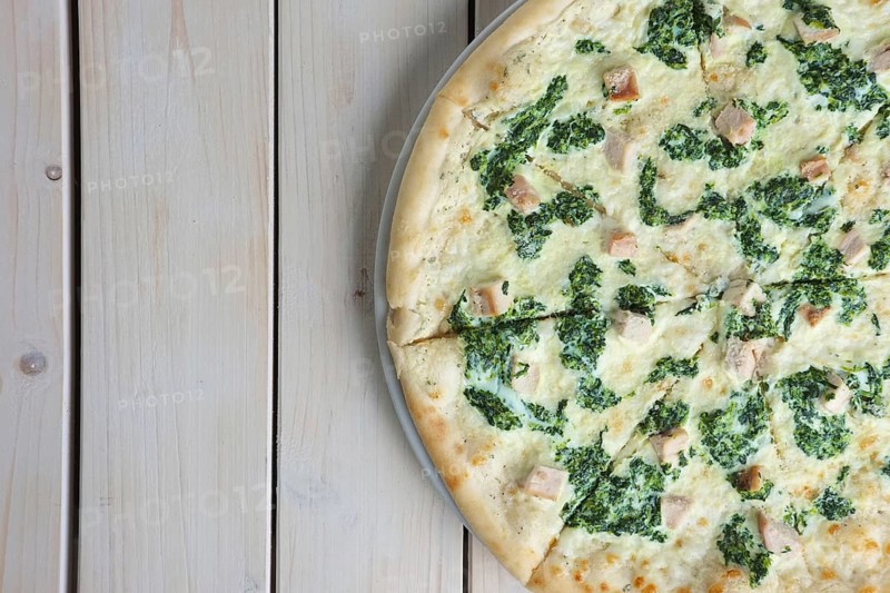 Top view of half of pizza with spinach and chicken. Copy paste space