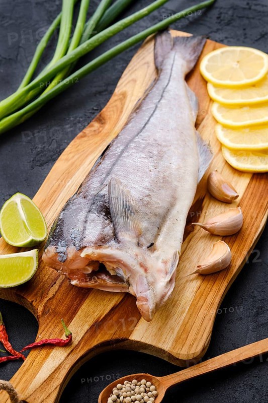 Raw fresh haddock carcass on wooden cutting board