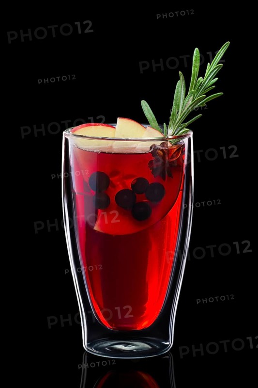 Double-walled glass with hot currant mulled wine isolated on black