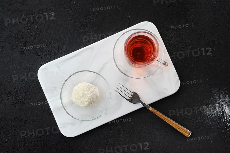 Top view of coconut biscuit dough cake and a cup of tea on a table