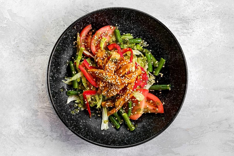 Top view of salad with chicken and teriyaki sauce