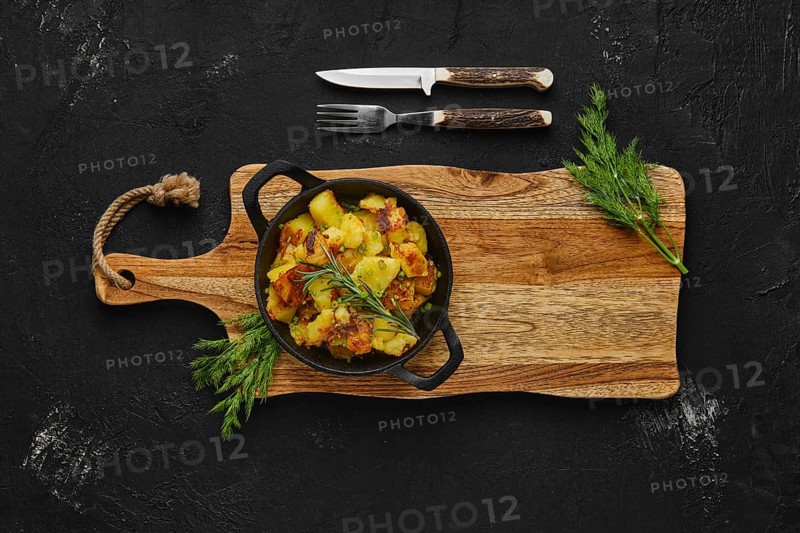 Top view of cast irom skillet with potato wedges baked in oven