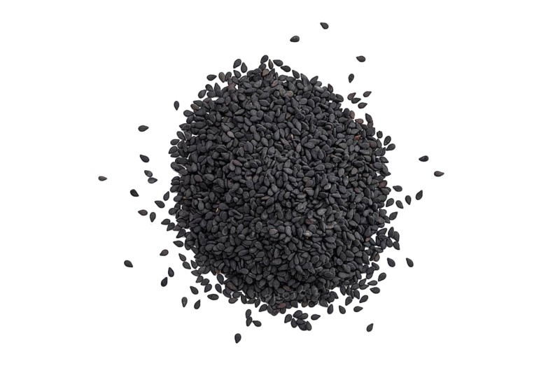 Top view of scattered black sesame seeds isolated on white background