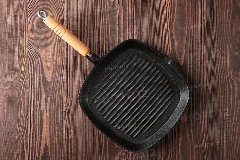 Cast-iron pan top view on wooden background