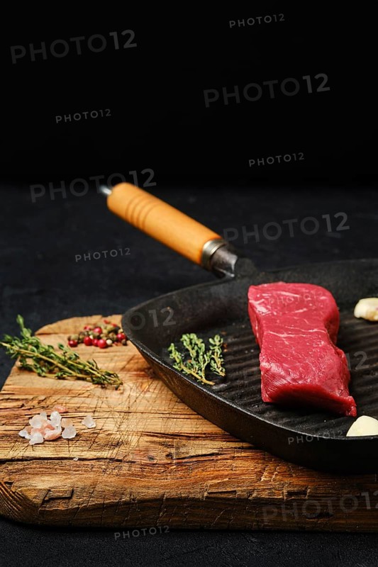 Raw boneless beef tri-tip steak on cast iron skillet