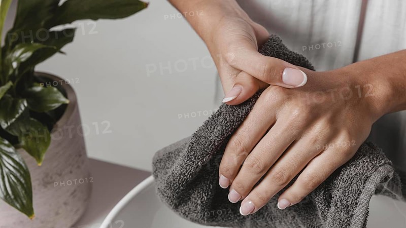 Person drying her hands towel close up