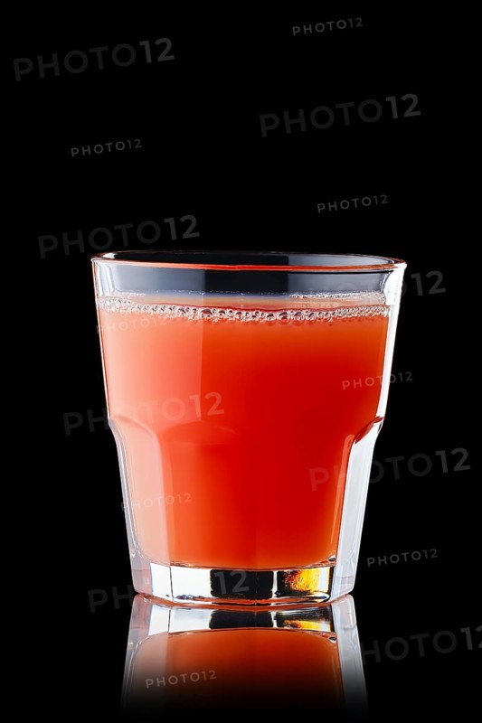 Fresh grapefruit juice in rocks glass isolated on black background