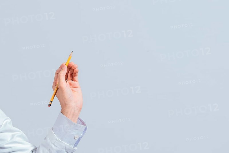 Hand with a pencil pointing at a blank space. Male hand holding a pencil on a blank. Man fingers holding a pencil with blank space. Person's hands holding a pencil on a space for text