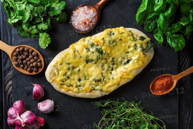 Tasty pita bread baked with herbs and spice surrounded with ingredients