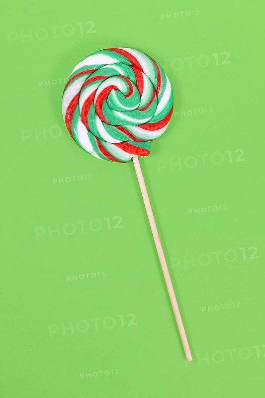 Lollipop with Christmas colors on green background