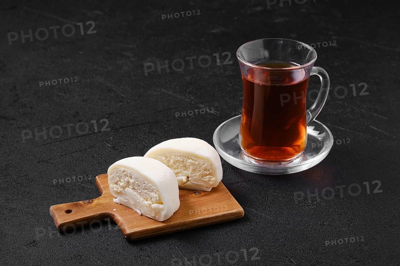 Sweet dessert mochi with coconut chips cut on half with fruit tea