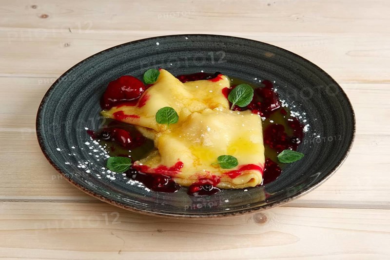 Pancakes with cherry jam decorated with mint leaves