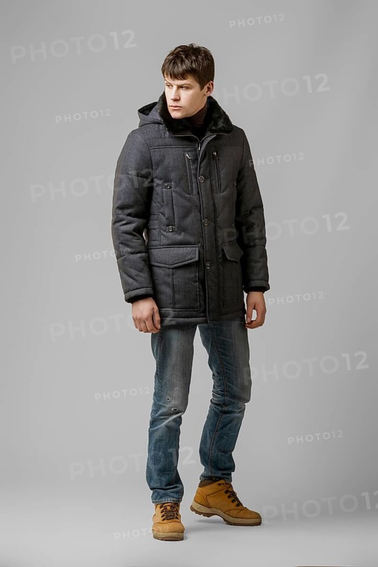 Full length portrait of handsome man in warm winter coat posing in studio