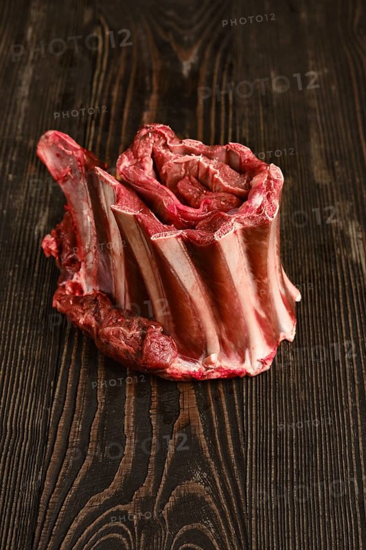 Raw rolld deer ribs over wooden background