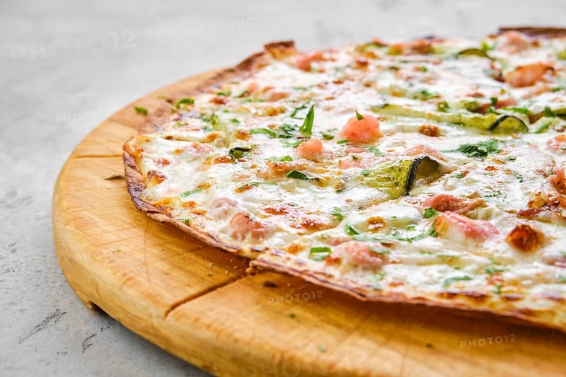 Thin-crust pizza dough with shrimps and zucchini