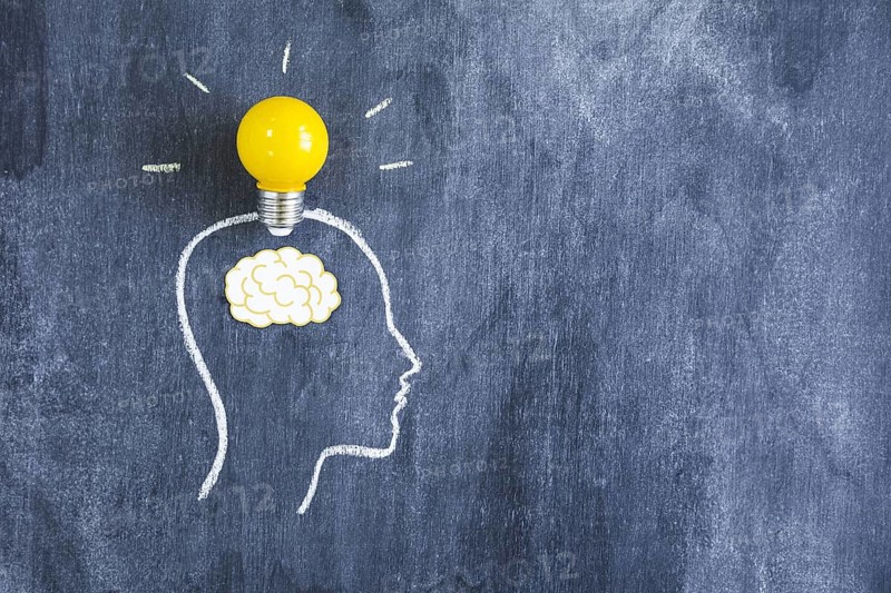 Yellow light bulb paper cutout brain outline face made with chalk blackboard. Resolution and high quality beautiful photo