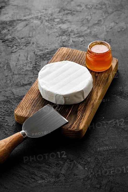 Piece of soft brie or camembert cheese on cutting board